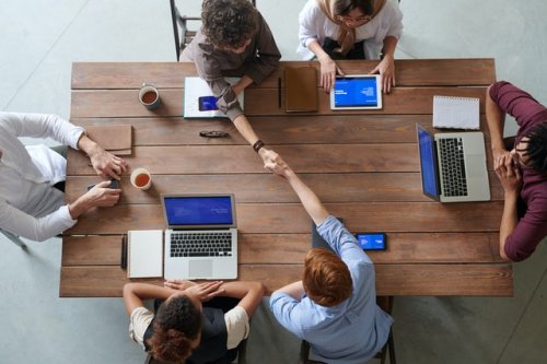 six people meeting at a desk